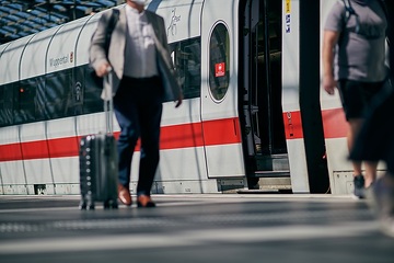 Reisende auf dem Bahnsteig im Hauptbahnhof Berlin vor ICE