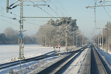 Symbolbild: Blick aus dem Führerstand während einer Zugfahrt in winterlicher Atmosphäre auf einer zweigleisigen elektrifizierten Hauptstrecke im Netz der DB.